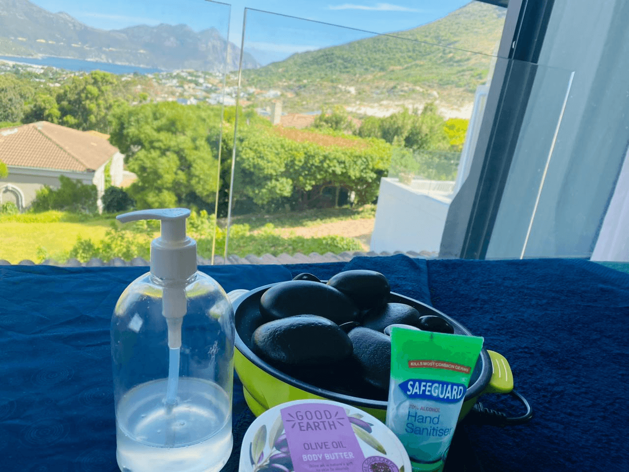 Mobile spa setup in Sea Point apartment — massage therapist preparing hot stones for at-home treatment, Cape Town Atlantic Seaboard